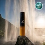 AK PURE SKIN Brightening Exfoliating Cleanser bottle placed in natural Icelandic waterfall setting – surrounded by rocks and flowing water, highlighting the clean, natural origin of the formula